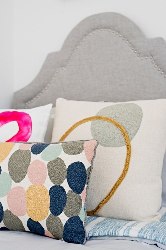 Throw pillows on top of bed in bedroom in kid's room