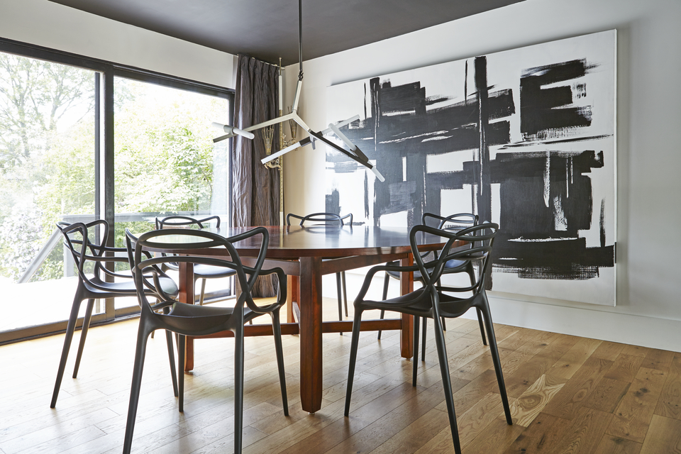 Minimalist dining room with large artwork and black chairs